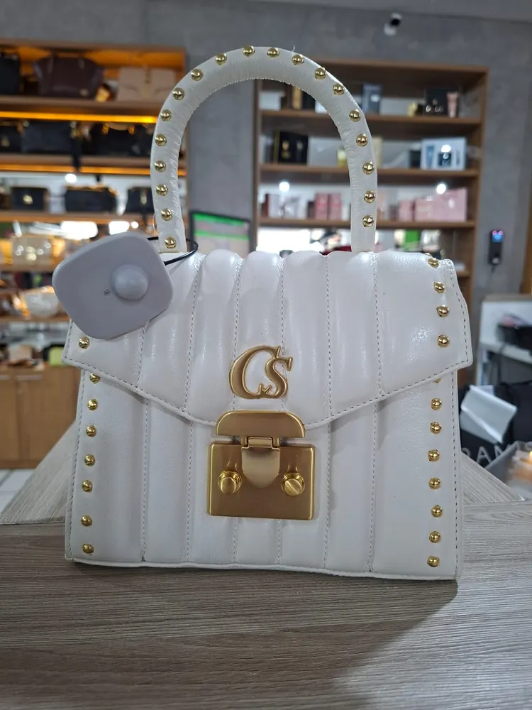 Bolsa de couro com etiqueta antifurto presa por cabo de aço